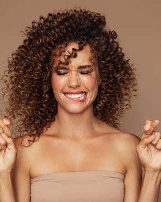 Voluminous brown curls, smiling